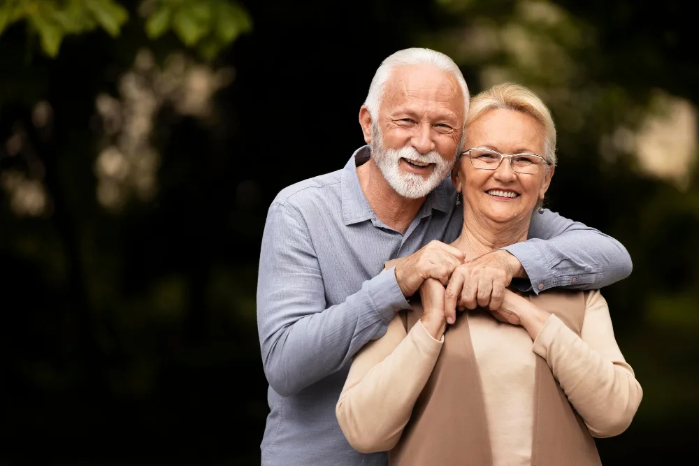 Pareja de personas mayores sonriendo y luciendo saludables